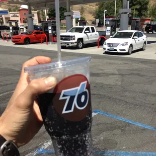 a hand holding a cup of soda
