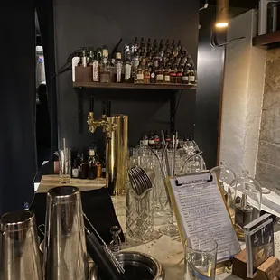 a bar counter with a menu and wine glasses