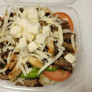 meat, cheese, and vegetables in a plastic container