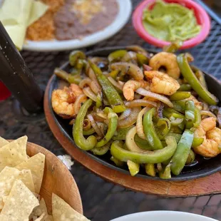 a plate of shrimp, peppers, and tortillas