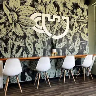 tables and chairs in front of a wall mural