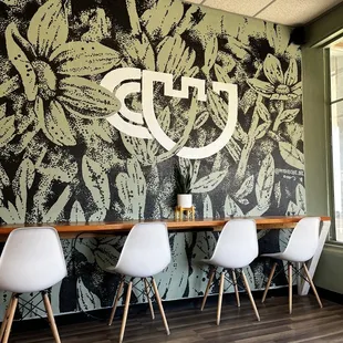 tables and chairs in front of a wall mural