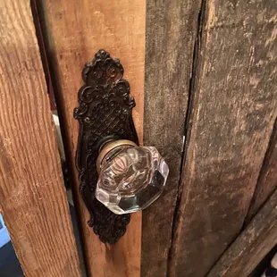 a glass door handle on a wooden door