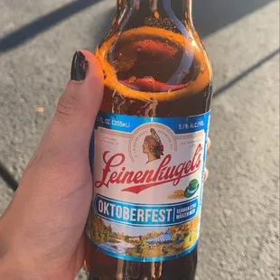 a hand holding a bottle of beer