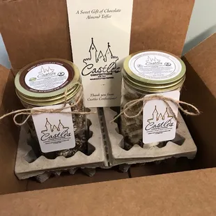 two jars of confections in a cardboard box