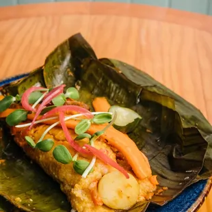 Vegan Tamal Seasonal vegetables, sofrito, organic corn, wrapped in banana leaf