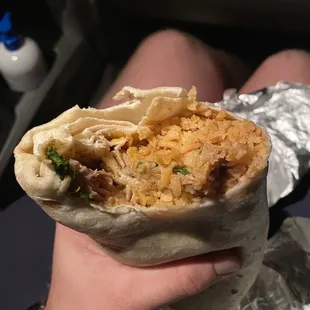 a hand holding a burrito