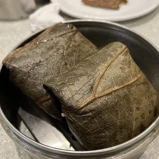 a bowl of rice wrapped in a leaf