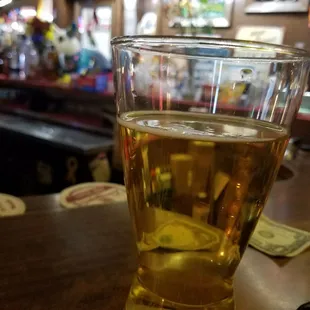 a glass of beer on a bar