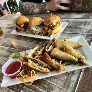 Cheesesteak eggrolls and three mini sliders, burger cheesesteak and buffalo chicken