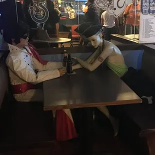 two mannequins sitting at a table