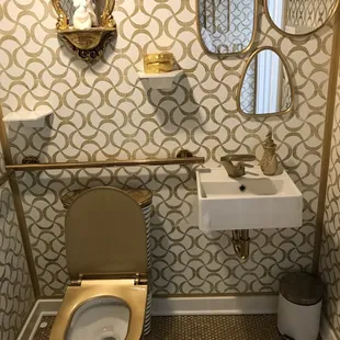 a bathroom with a toilet, sink and mirror