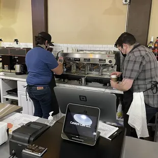 a man and a woman working in a coffee shop