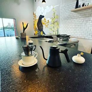 a coffee pot and a cup on a counter