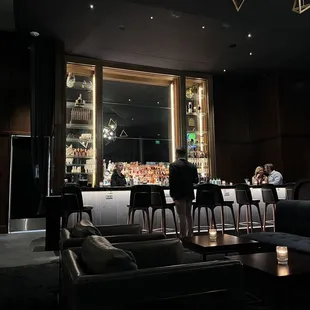 people sitting at a bar in a dimly lit room