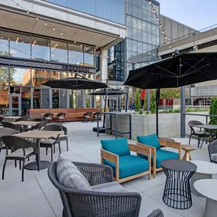 a patio with tables, chairs, and umbrellas
