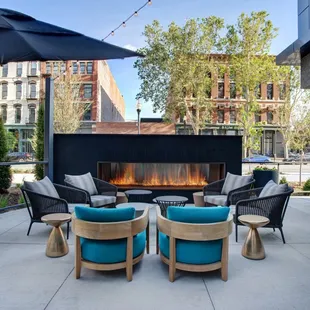 a patio with a fire place and lounge chairs