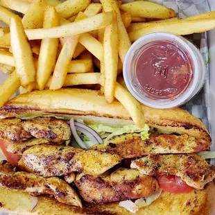 a grilled chicken poboy with french fries and ketchup