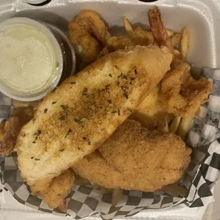 Fried tilapia and shrimp with fries.