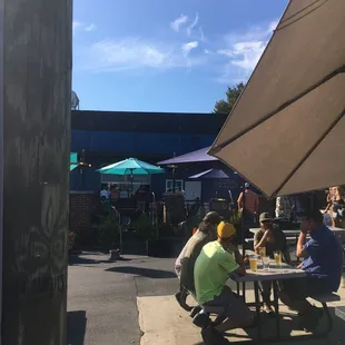 people sitting at tables under umbrellas
