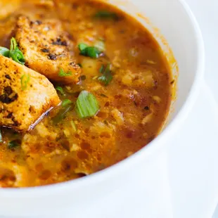 a bowl of soup with tofu and green onions