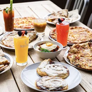 ows a table full of pizzas and drinks