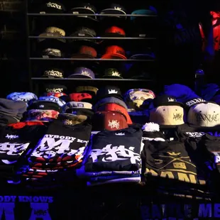 a table full of hats and t - shirts