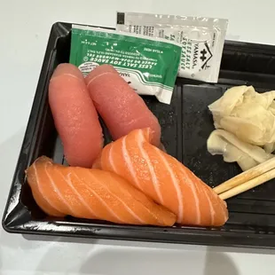 a tray of sushi and chopsticks