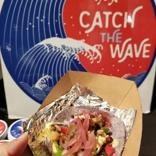 a hand holding a burrito