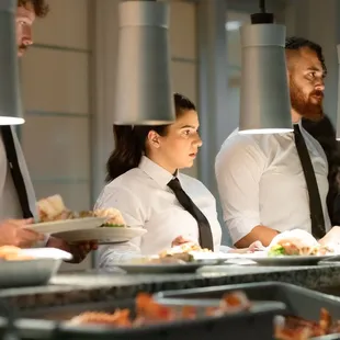 Waitstaff ready to pass plated dinner