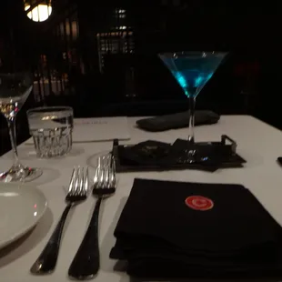 a table setting with a drink and silverware