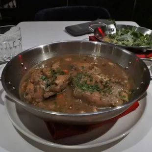 a bowl of stew and a plate of salad