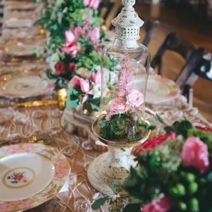 Romantic tablescape, featuring roses, tulips, terrarium arrangement, and couture linen.