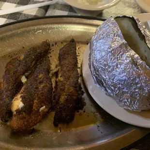 a plate of fish and a baked potato