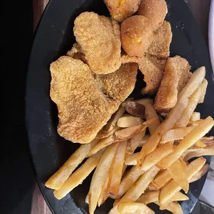 Fried catfish with fries. The meal comes with two sides and hush puppies.
