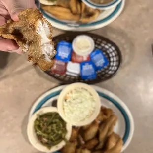 a person holding a piece of fried fish