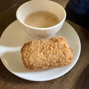 a bowl of soup and a biscuit on a plate