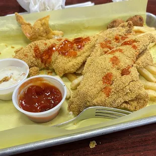 Catfish filets, 1 of the shrimps, fries, hush puppies, tartar sauce, ketchup.