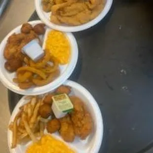 a tray of fried chicken, fries, macaroni and cheese