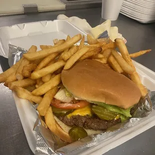 a hamburger and fries in a styrofoam container