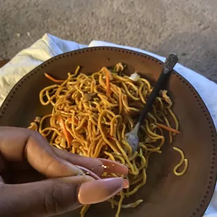 a person eating a plate of noodles