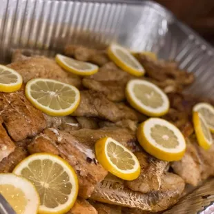 a pan of chicken with lemon slices
