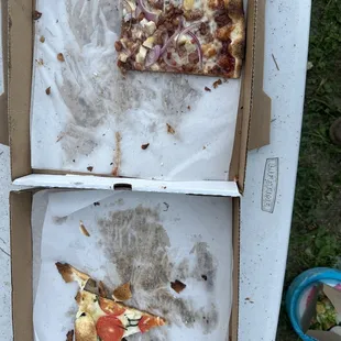 two slices of pizza left in a box