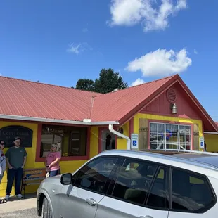two people standing outside of a restaurant