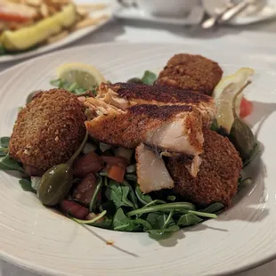 Honey arugula salad topped with blackened and salmon