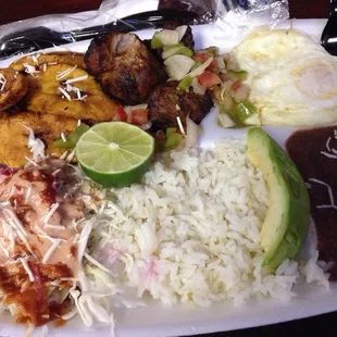 Catrachita plate with pork pieces, cabbage, eggs, rice, beans, cheese, avocado and plantain