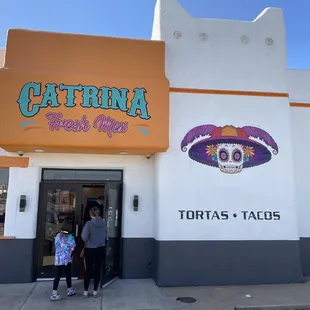 two people standing in front of a store