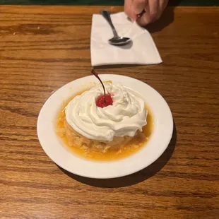 a dessert with whipped cream and a cherry on top