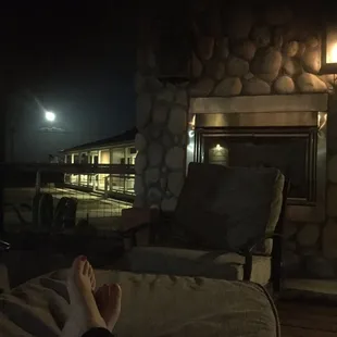 a person&apos;s feet on a couch in front of a fireplace