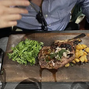 a steak and potatoes on a cutting board